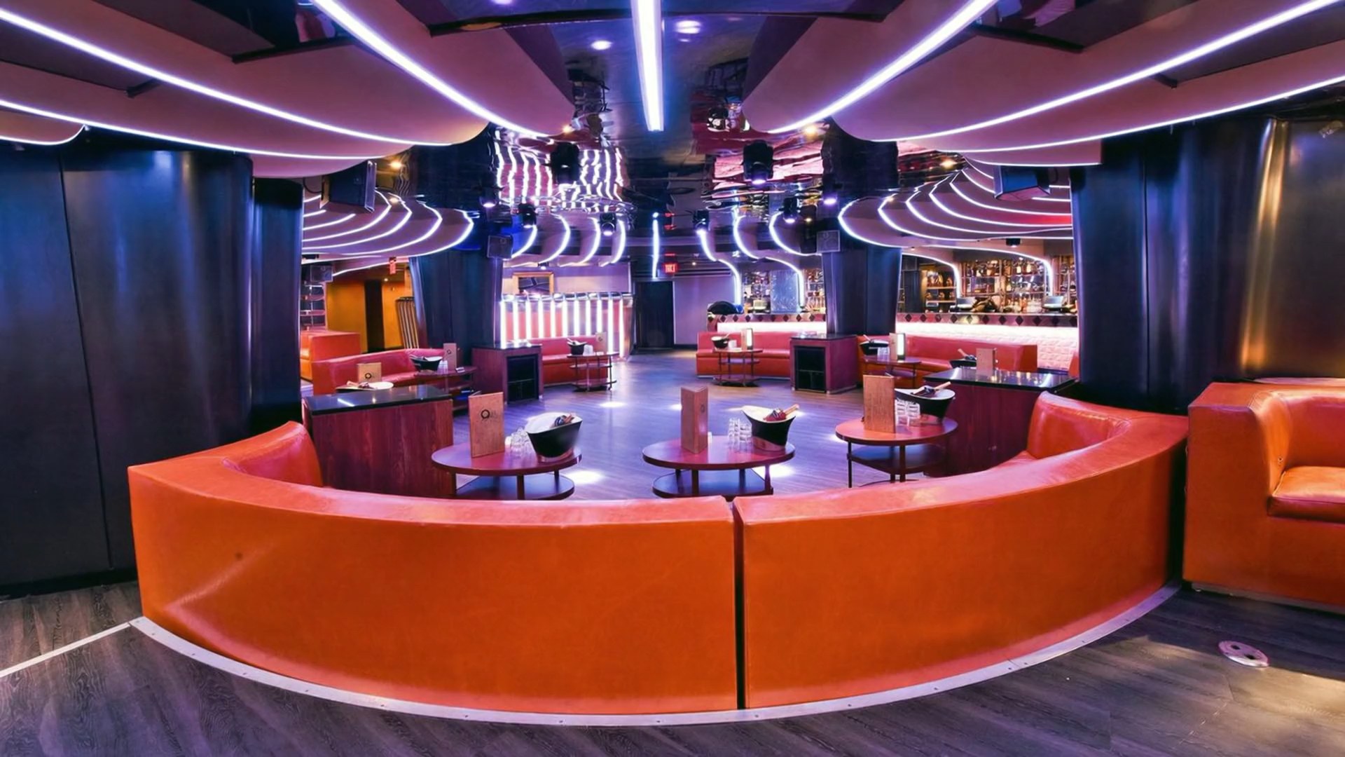 Strand's lounge with orange booths and a lit ceiling